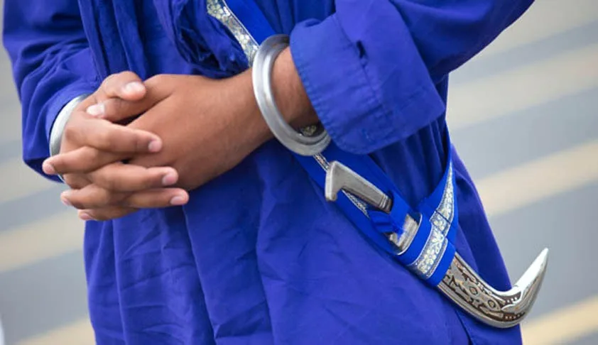 a person in a blue robe with silver bracelets and a curved knife in a belt, hands clasped in front. overlaid text reads 'i'm…