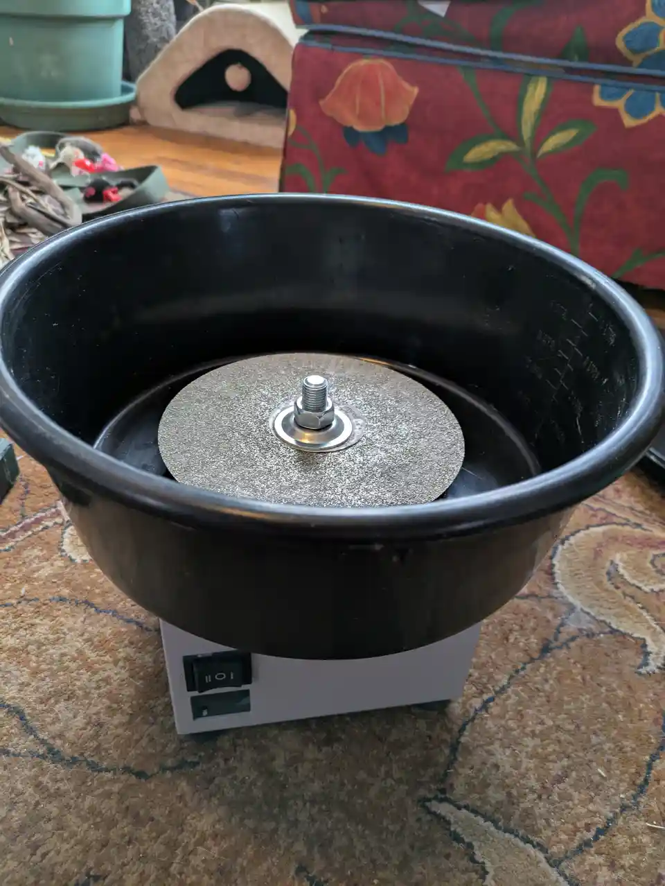 A black plastic bowl, typically used for a cotton candy machine, sits on a white base with a toggle switch. Inside the bowl…