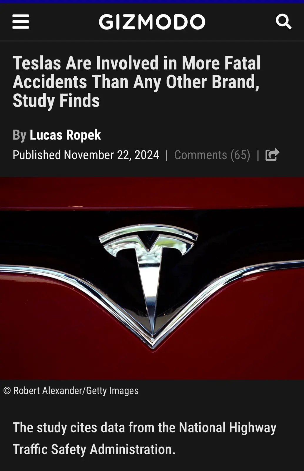 A screenshot of a Gizmodo news article header showing a close-up of a red Tesla car's front emblem. The headline reads…