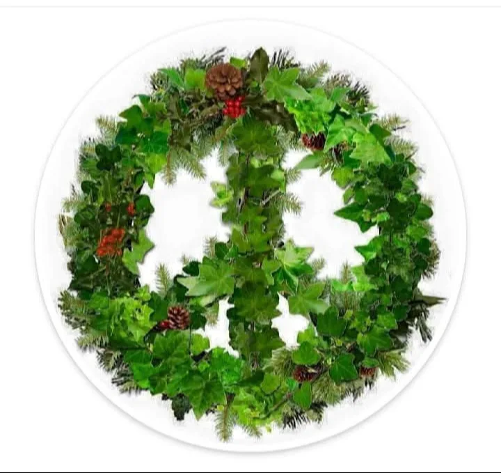 A circular holiday wreath made of green ivy, pine needles, pinecones, and red berries is arranged to form the shape of a…