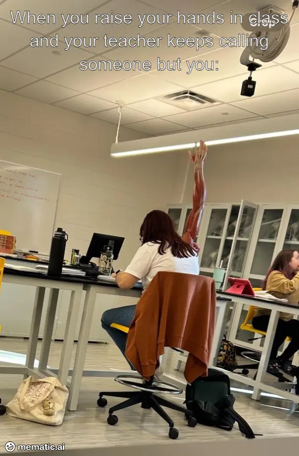 A student sits at a desk in a classroom, raising one hand high in the air. Their arm is digitally altered to show detailed…