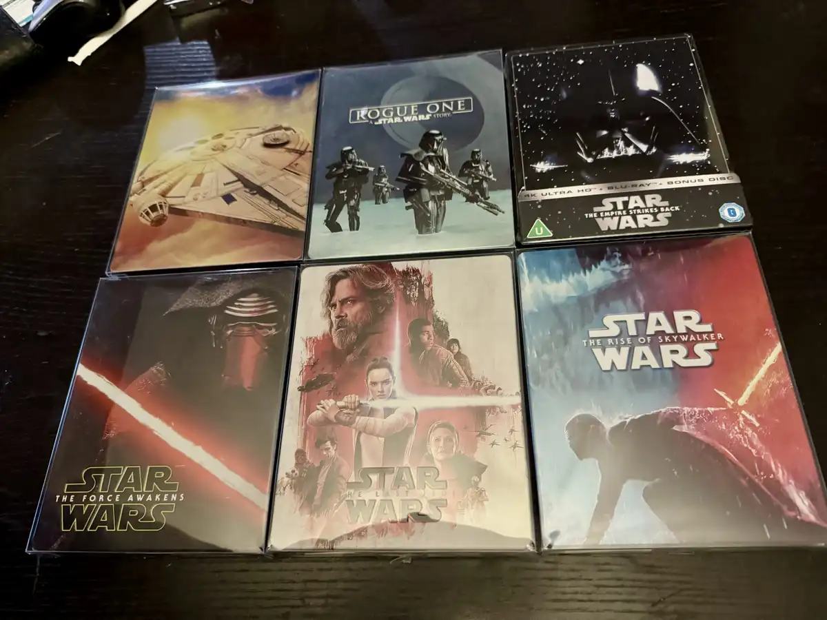 Six Star Wars Blu-ray cases are arranged in two rows on a dark surface, featuring 'The Force Awakens', 'The Last Jedi', 'The…
