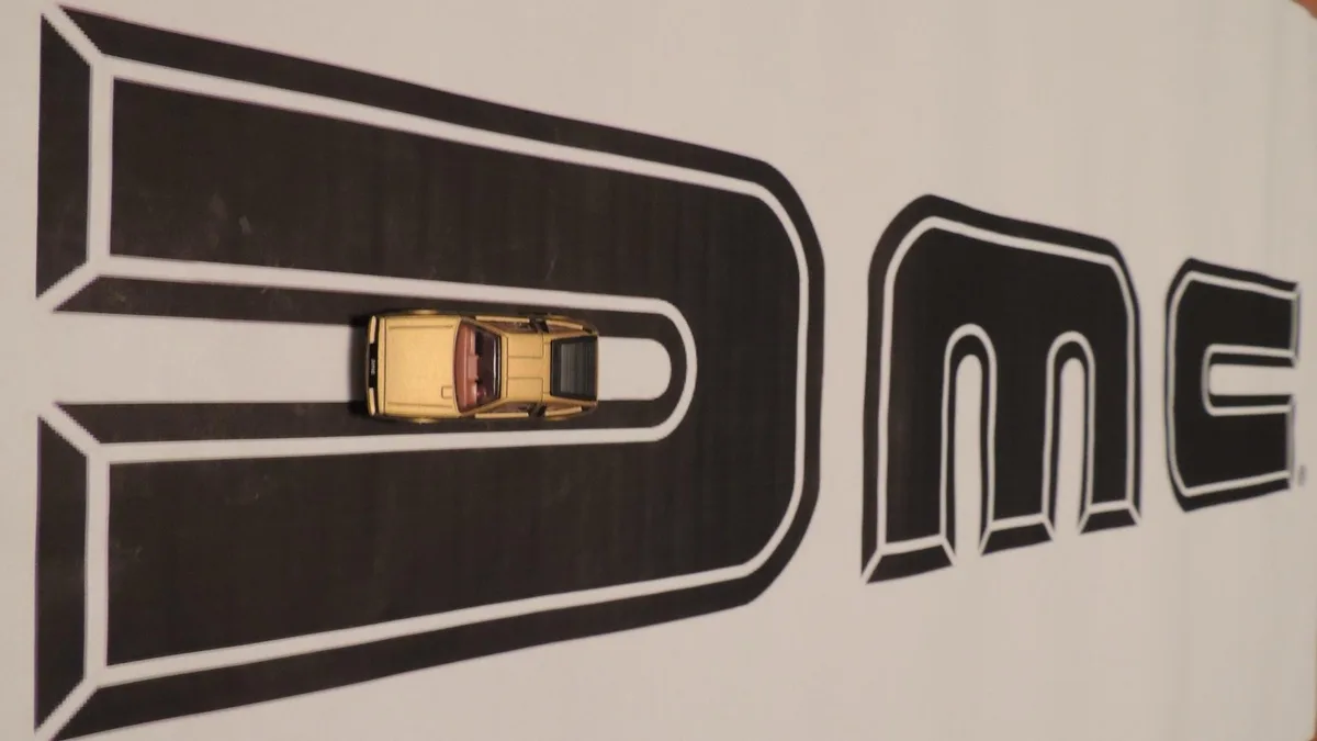 A small yellow toy car is placed inside the large black letter 'D' of the word 'DONE', which is printed in bold, blocky…