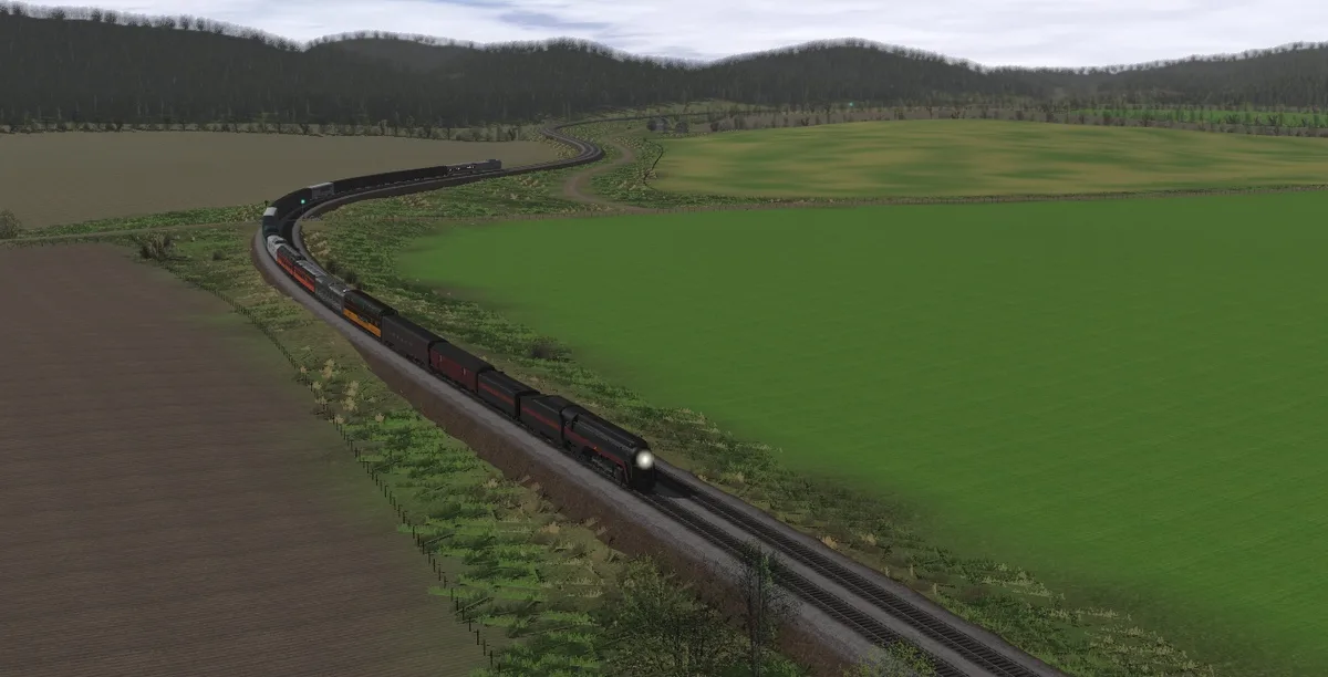 A long train with a black and red locomotive travels along a curving railway track through a rural landscape of green fields…