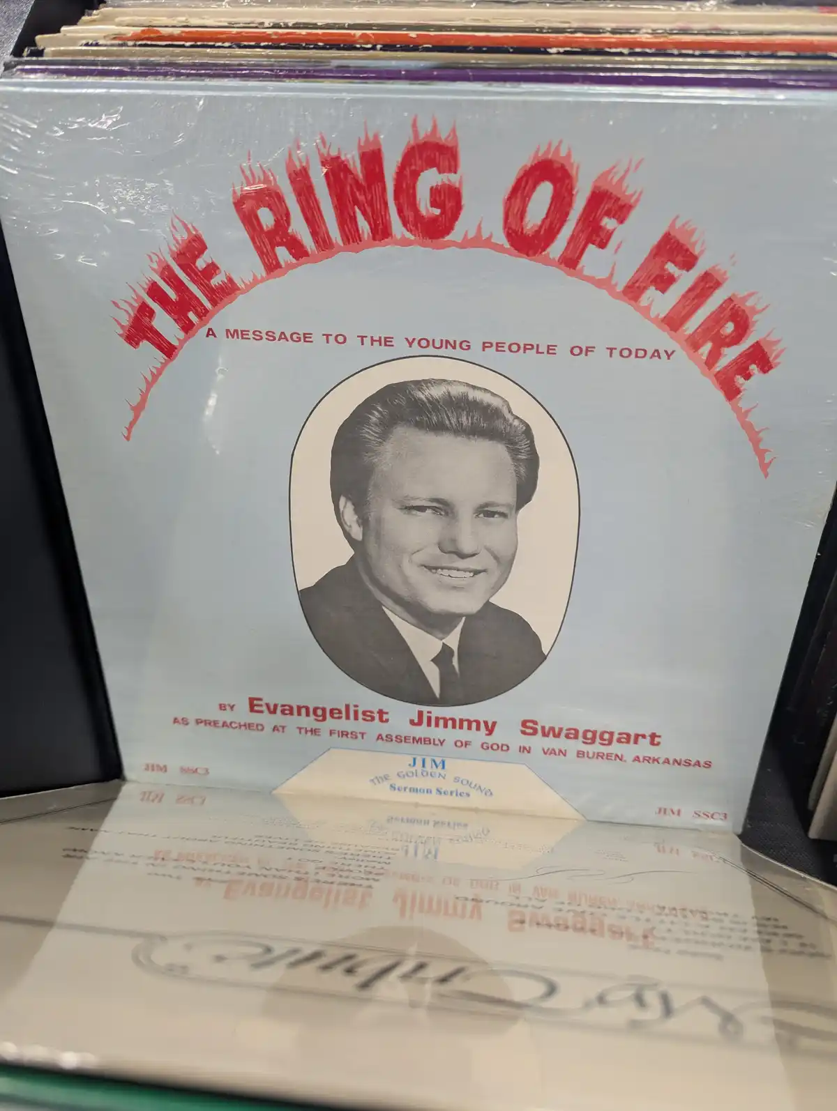 A close-up photo of a vintage vinyl record sleeve for 'The Ring of Fire' by Evangelist Jimmy Swaggart, featuring a…