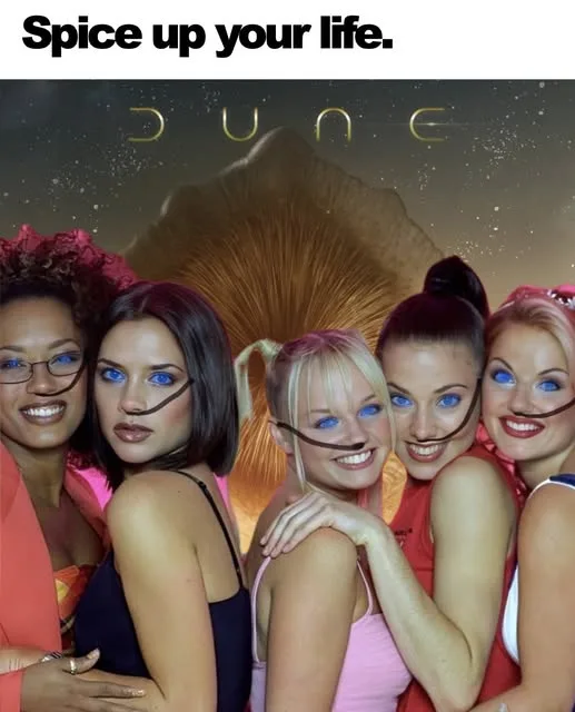 The image features five women posing together, with digitally added black mustaches drawn across their upper lips. Behind…