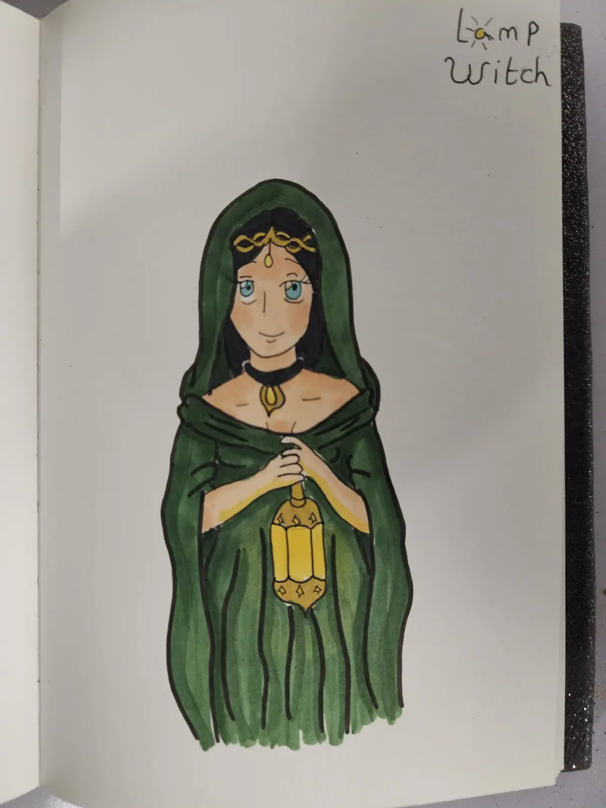 A hand-drawn illustration in a sketchbook shows a woman in a green hooded cloak holding a golden lantern. She has blue eyes…