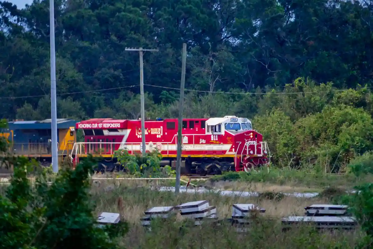 A red train engine with the number 911 prominently displayed on its front and side, along with the text 'HONORING OUR 1ST…
