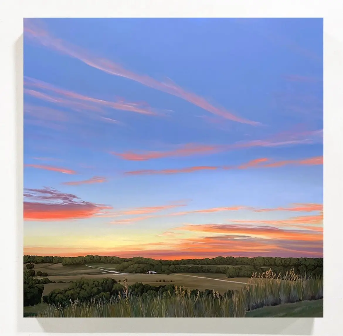 A serene landscape painting depicts a vast field with tall grasses in the foreground, rolling hills, and a distant treeline…