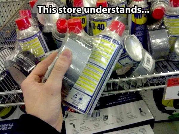 A hand holds a bottle of WD-40 in a store aisle, surrounded by other similar products on metal shelves. The overlaid text…