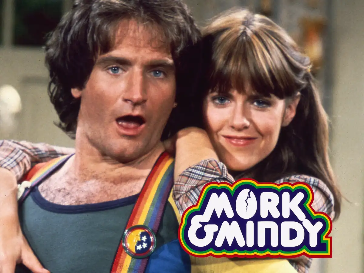 A still from the TV show 'Mork & Mindy' featuring the characters Mork (with wide-eyed shock) and Mindy (smiling while…