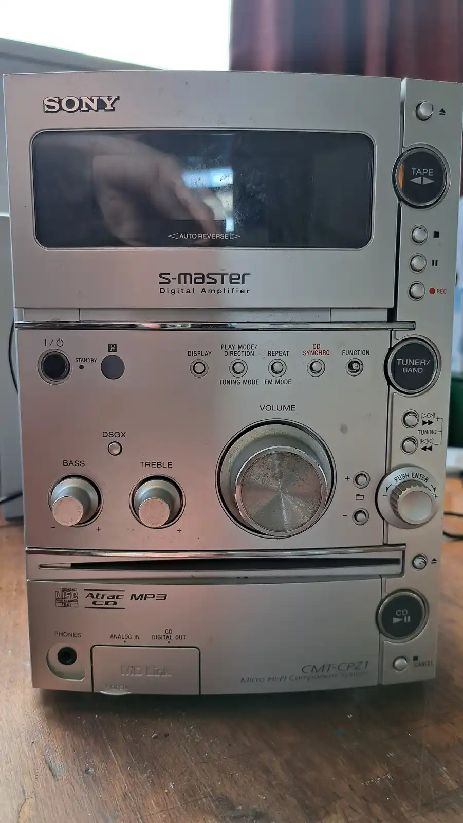 A close-up photo of a silver Sony CMT-CPZ1 Micro Hi-Fi Component System, showing its tape deck, CD player, and amplifier…