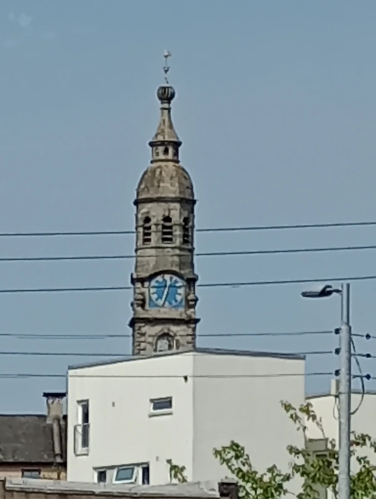A stone clock tower with a blue clock face shows a broken clock with hands pointing to 10:10, overlaid with the text 'the…