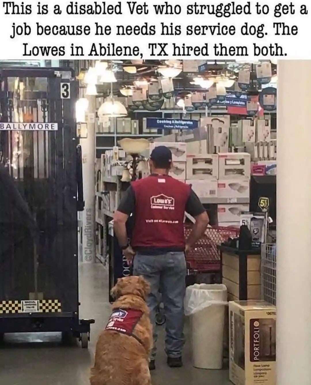 A man wearing a red Lowe's Customer Service vest walks through a Lowe's store aisle, viewed from behind. A golden-colored…