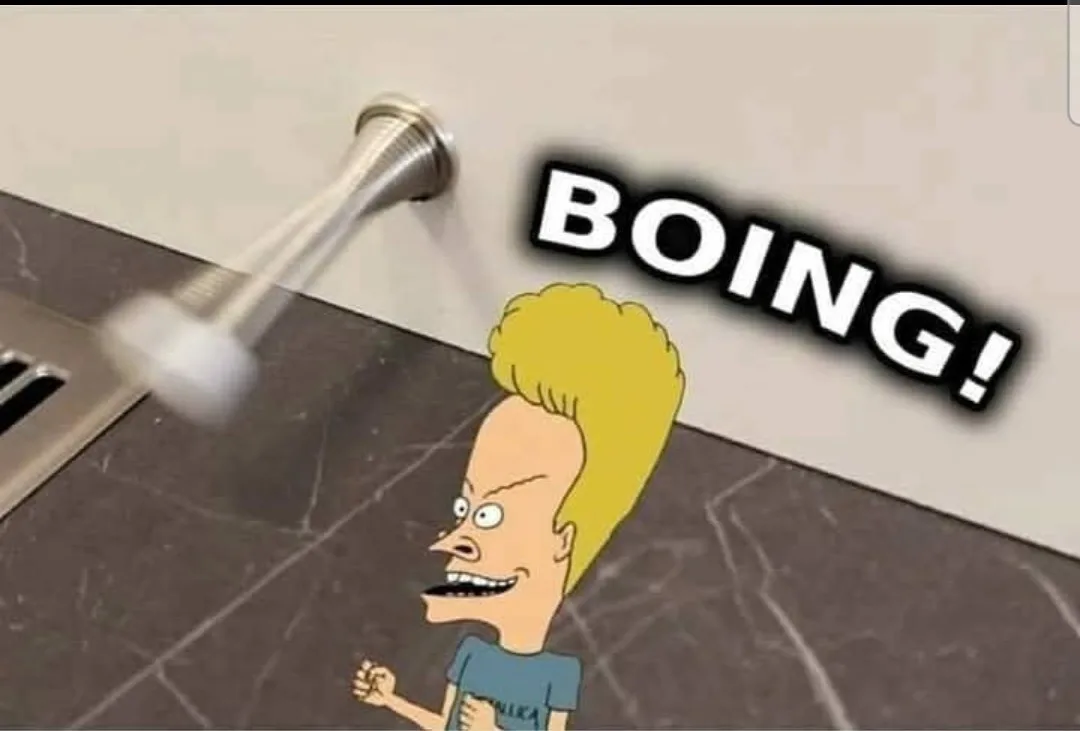 A cartoon character with a blonde mohawk and a blue shirt is shown in a bathroom with a metallic showerhead swinging toward…