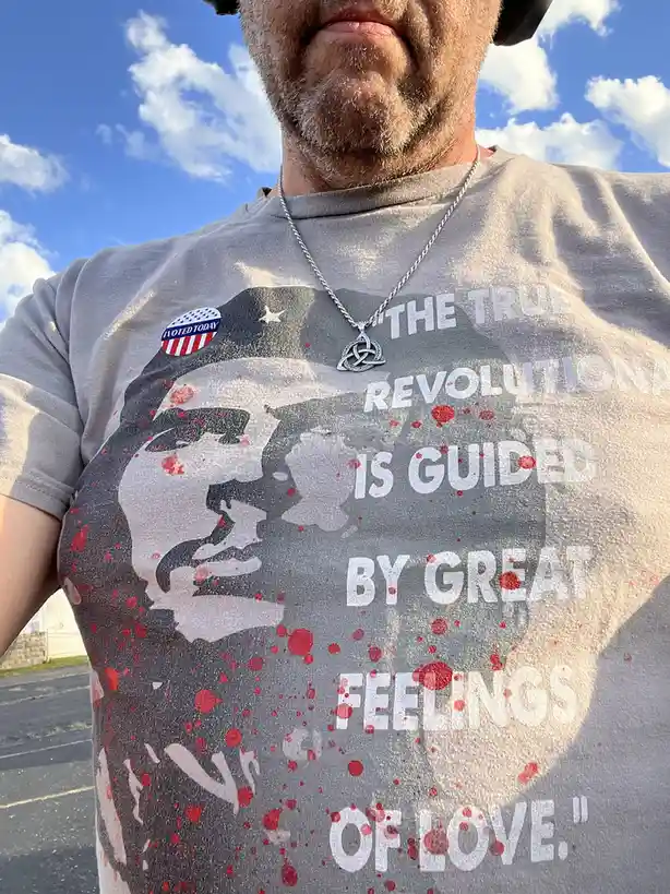 A man wearing a gray t-shirt with a graphic of Che Guevara, red splatter effects, and the quote 'THE TRUE REVOLUTIONARY IS…