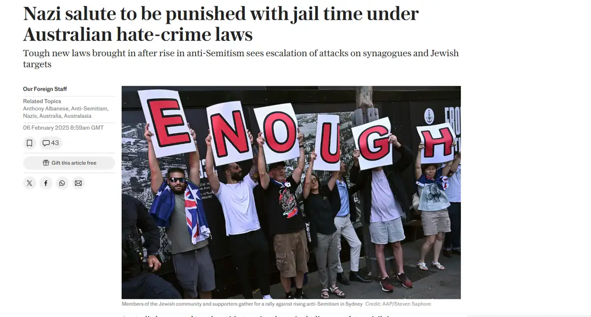 A group of protesters holds up individual signs spelling out the word 'ENOUGH' in large red letters. They are gathered…