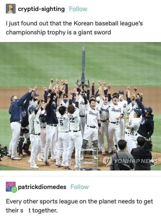 A group of baseball players in white uniforms celebrate on a field, raising their arms in triumph around a large, ornate…
