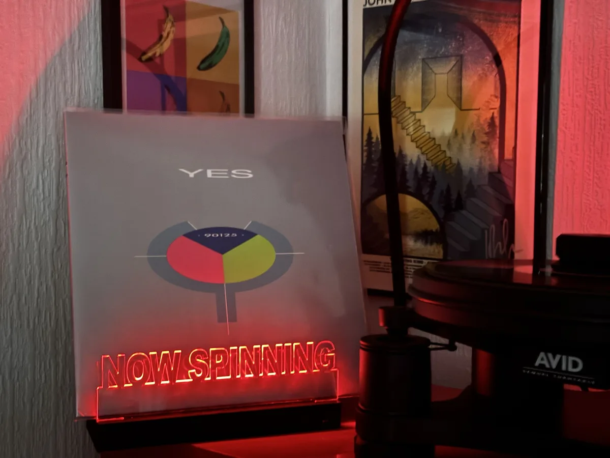 A vinyl record sleeve for the band YES, featuring the album title '90125' and a colorful circular graphic, is displayed next…