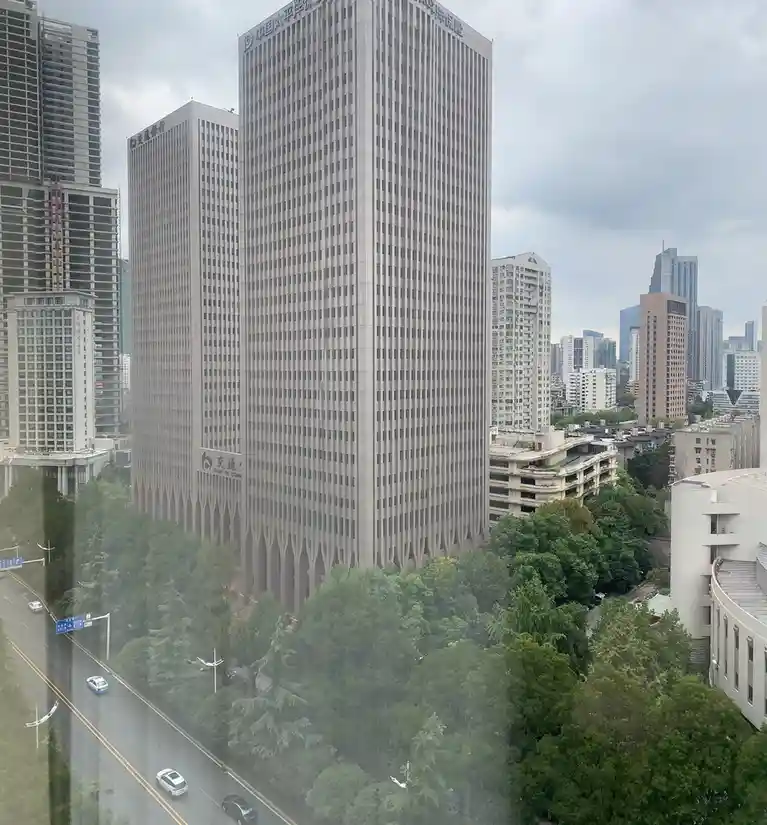 A high-angle urban photo shows a tall, beige skyscraper with '中国太平洋保险' (China Pacific Insurance) written in Chinese…