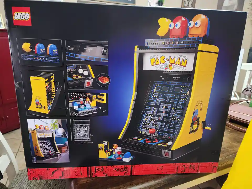 The image shows the back of a LEGO Pac-Man arcade machine set box, featuring a large illustration of the assembled yellow…