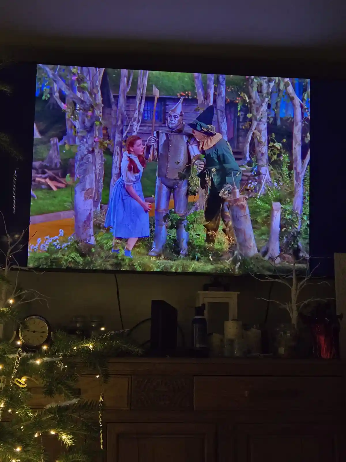 A television screen displays a scene from 'The Wizard of Oz' featuring Dorothy, the Tin Man, and the Scarecrow in a forest…