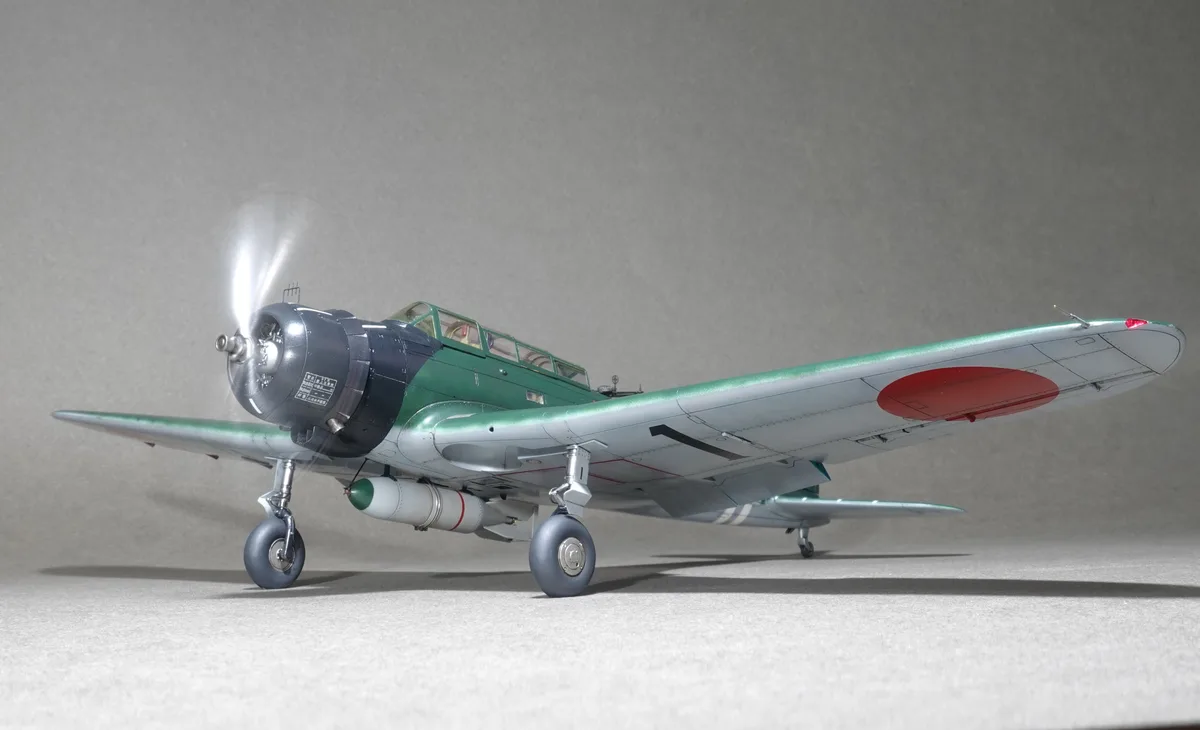 A detailed scale model of a Japanese military aircraft, likely a Nakadžima Sakae-powered plane, is shown on a grey surface…