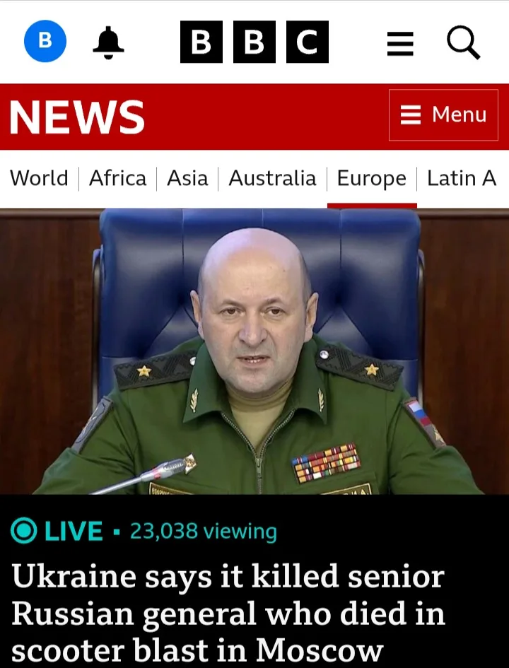 A screenshot of a BBC News webpage shows a bald man in a green military uniform with medals and epaulets, seated in a blue…