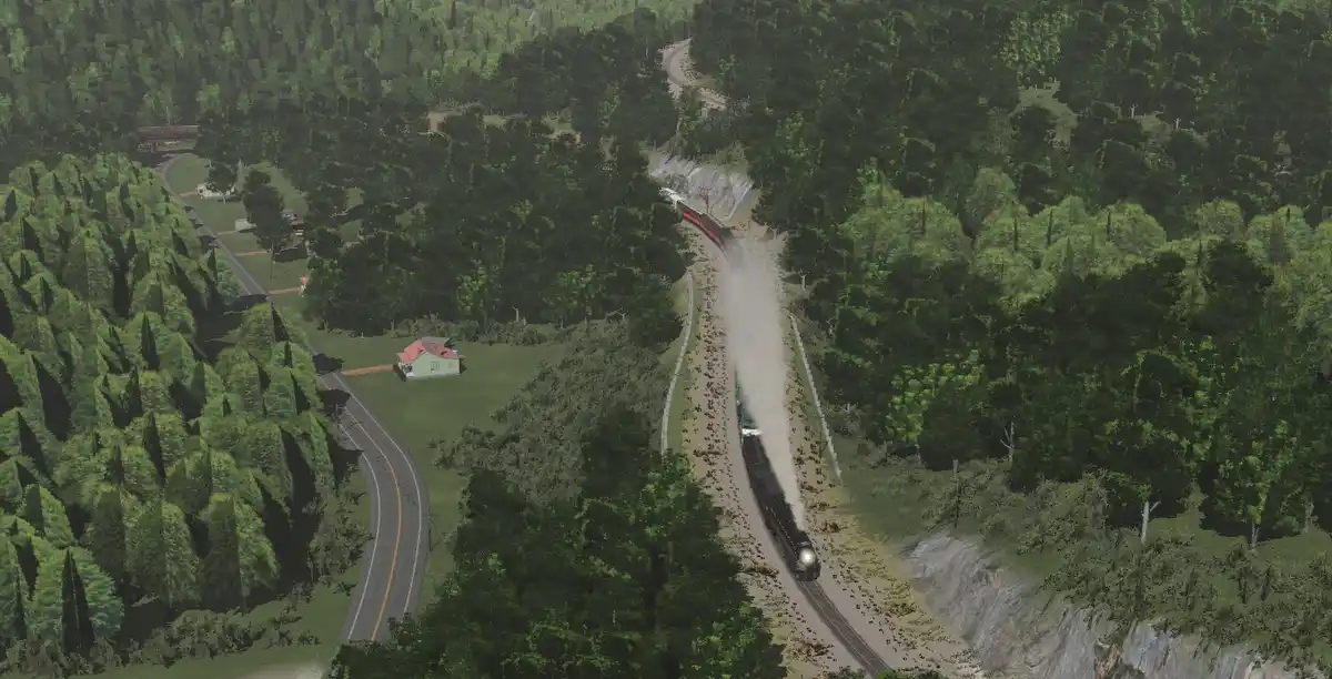 An aerial view of a train traveling along a winding track through a dense green forest, kicking up dust as it moves. A road…