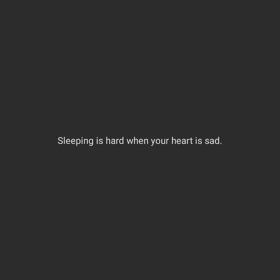A plain dark gray background with centered white text that reads 'Sleeping is hard when your heart is sad.' The image is…