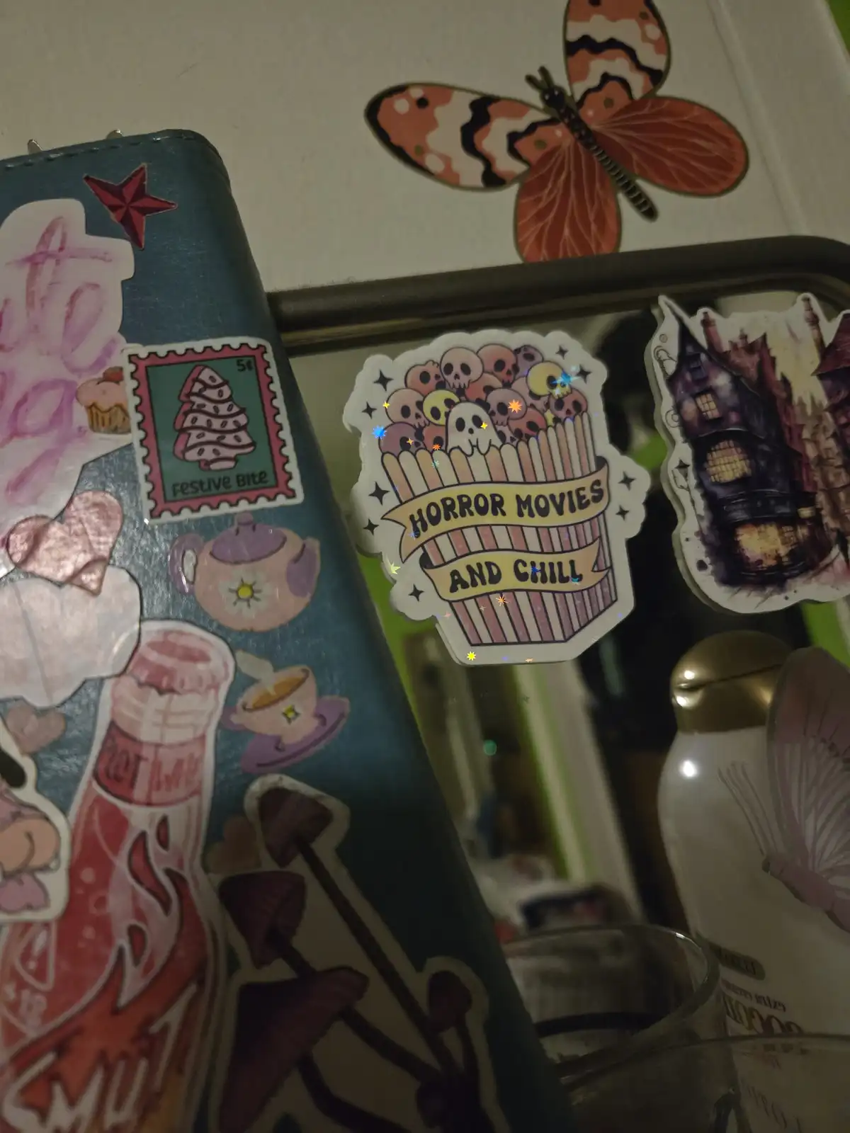 A close-up of a decorated surface with various stickers, including a prominent one shaped like a popcorn bucket filled with…