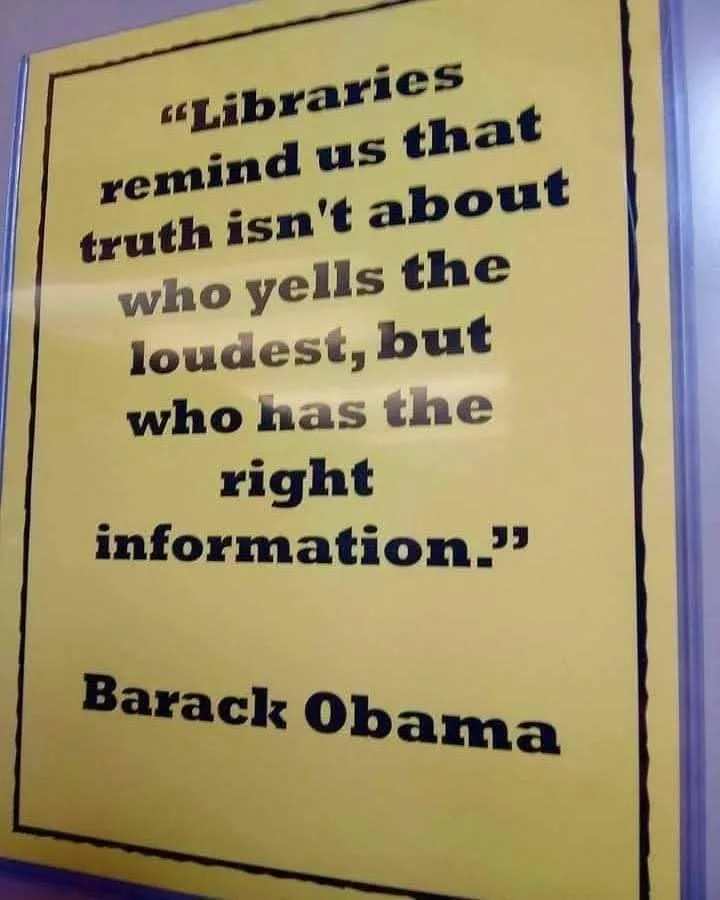 A yellow poster with black text displays a quote attributed to Barack Obama: 'Libraries remind us that truth isn't about who…