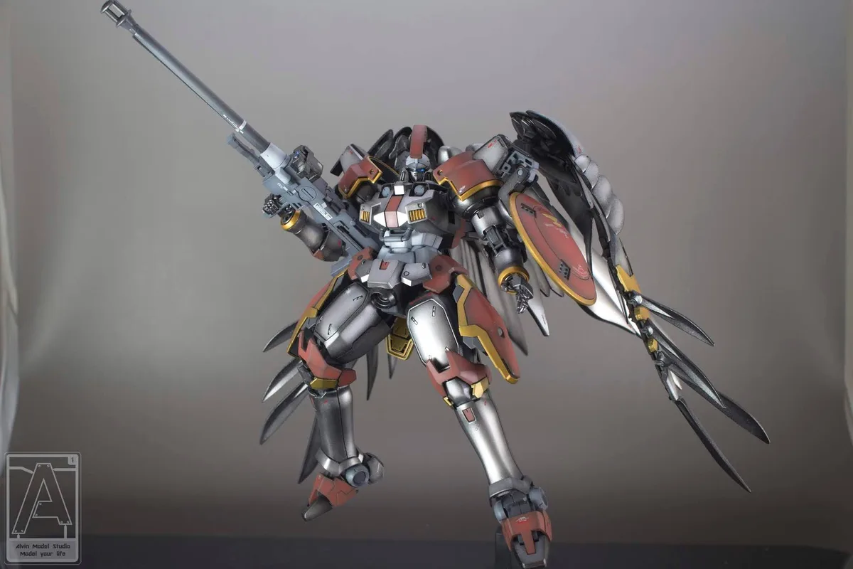 A highly detailed, custom-painted model of a red, silver, and gold mobile suit with wing-like armor and a large rifle, posed…