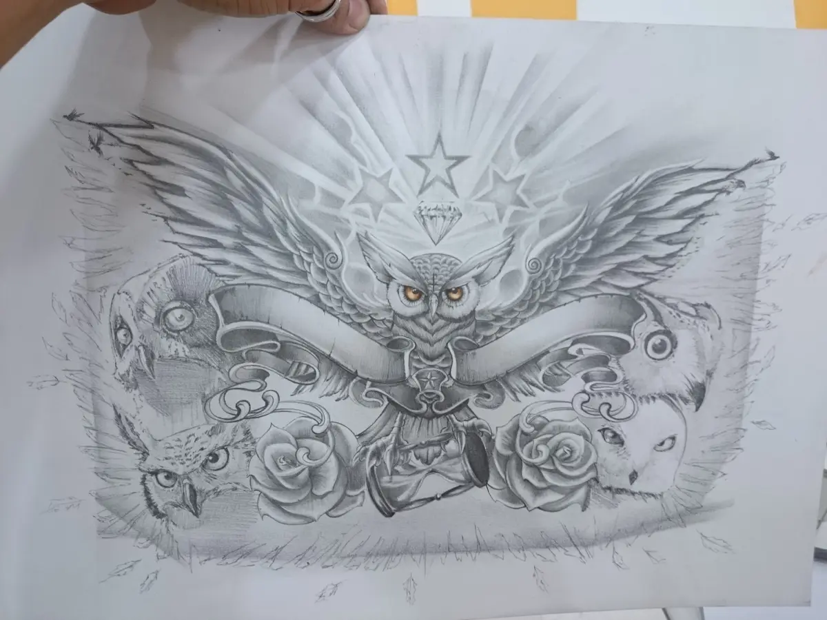 A detailed pencil sketch of a tattoo design featuring a central, majestic owl with spread wings and glowing orange eyes…