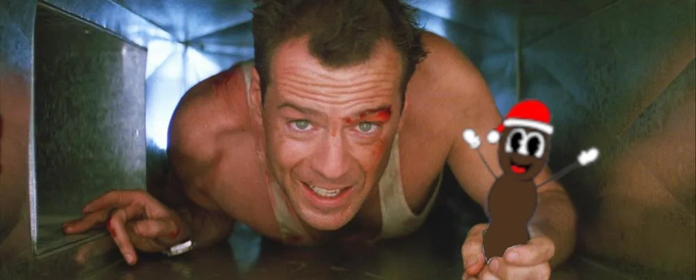 a man with blood on his face and a bruised expression is crawling through a metal duct, holding a cartoonish brown figure…