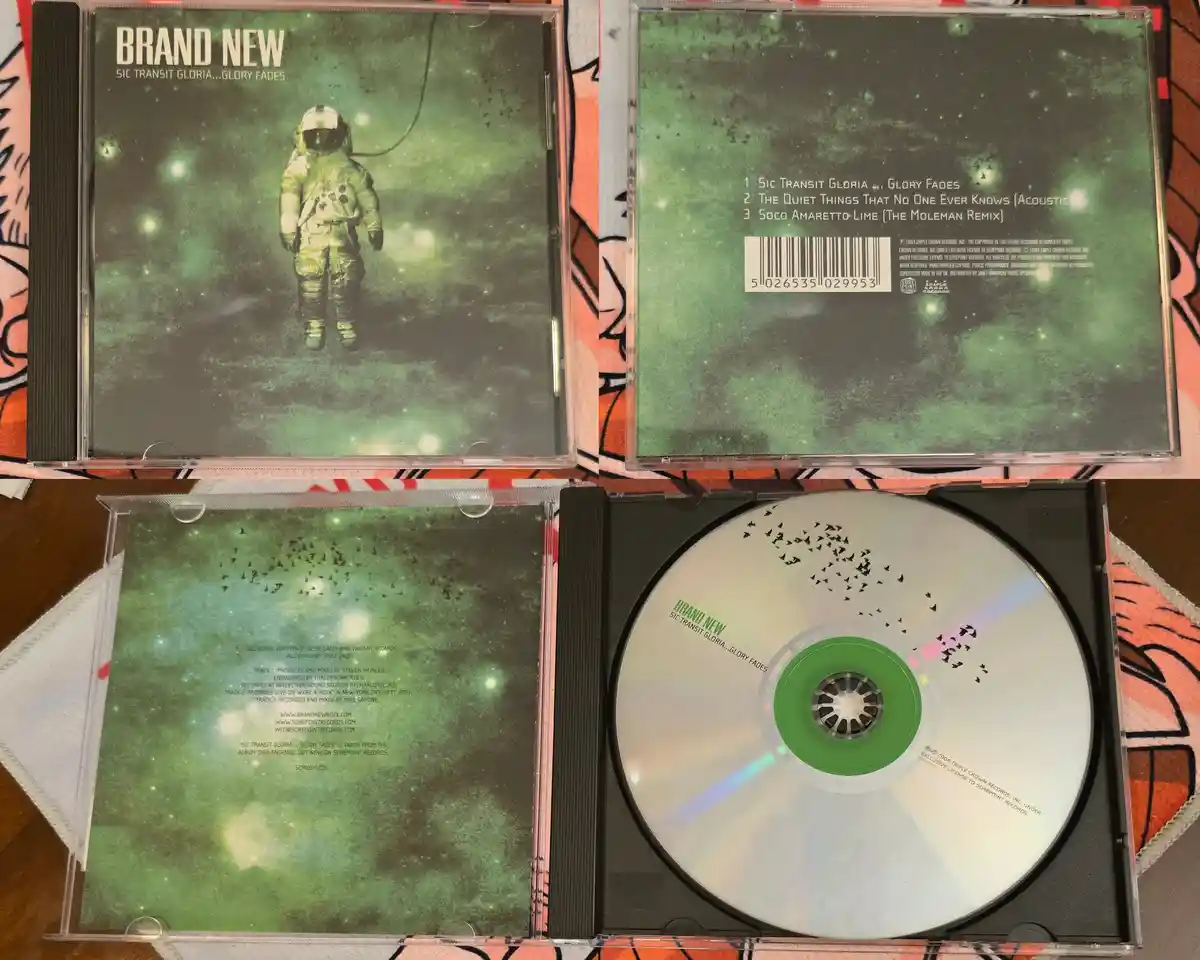 An open CD case for the album 'Sic Transit Gloria...Glory Fades' by Brand New, showing the front cover with an astronaut in…