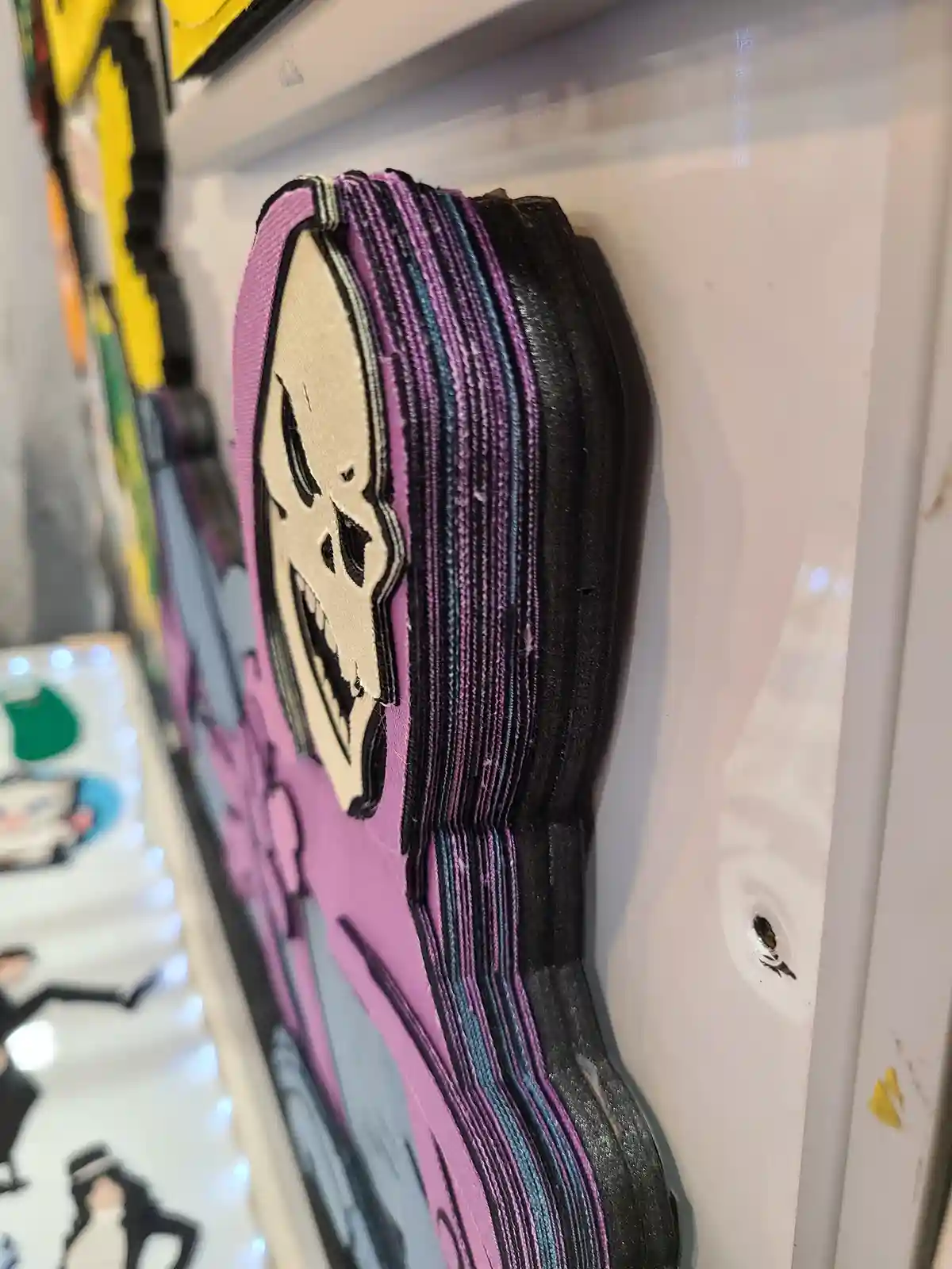 A close-up of a 3D embroidered patch of the character Death from 'Undertale', showing her skull face and long, layered…