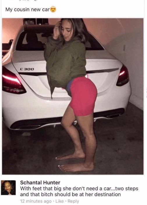 A woman in a green jacket and pink shorts stands barefoot in a garage, leaning against the trunk of a white Mercedes-Benz…
