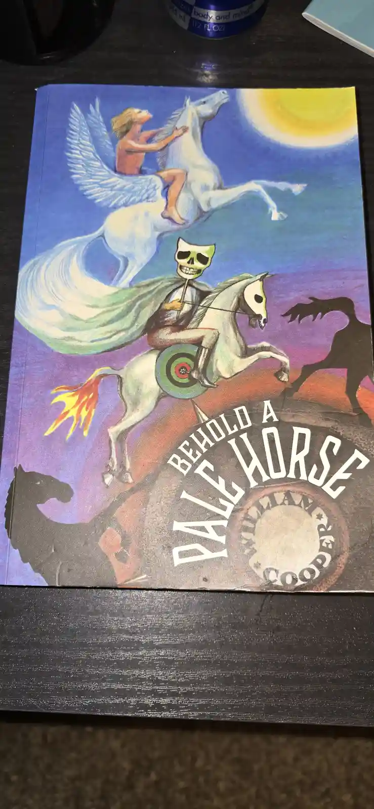 The image shows the cover of a book titled 'Behold a Pale Horse' by William Cooper. The cover art depicts a skeletal figure…