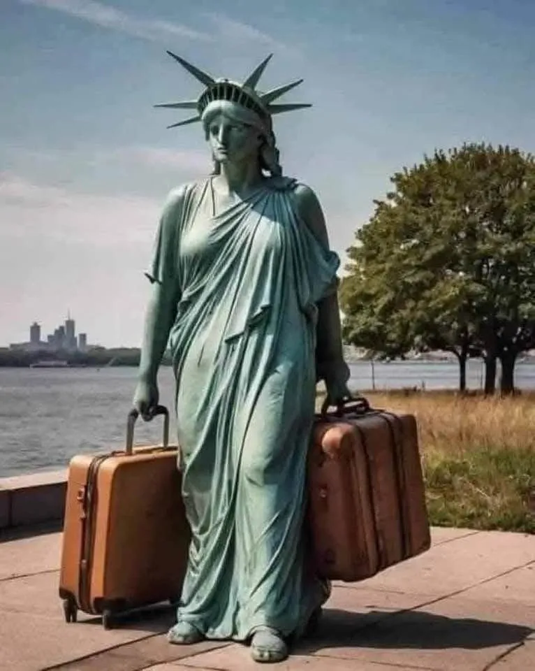 The Statue of Liberty, a large greenish copper statue, stands outdoors holding two vintage brown suitcases, one in each…