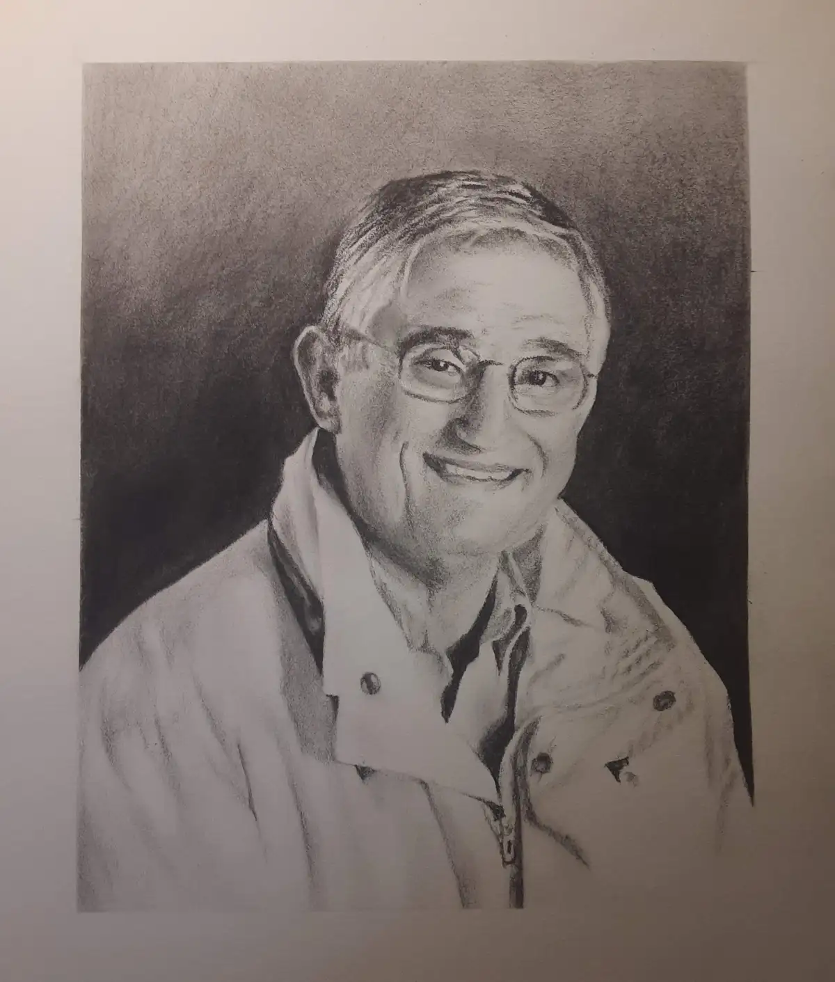 A detailed pencil sketch of an older man with glasses and a warm smile, wearing a collared jacket. The image has text…