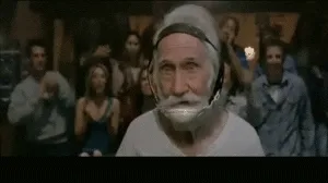 A sequence of six frames from a movie scene shows an elderly man with a white beard wearing a headset, initially looking at…