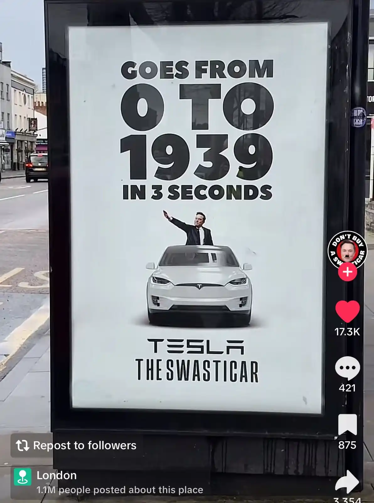 A street advertisement for a Tesla car features a man in a suit waving from the roof of a white Tesla Model X. The ad text…