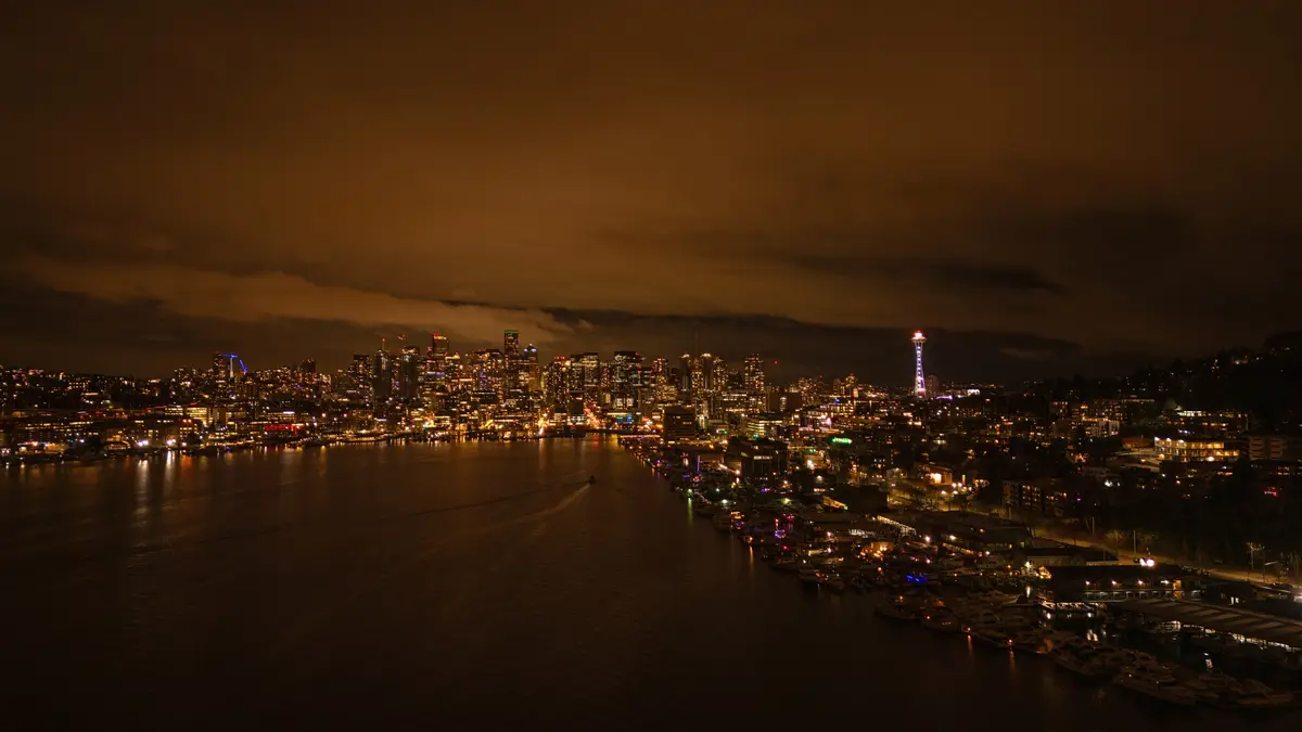A nighttime cityscape of Seattle, Washington, featuring the illuminated skyline, the Space Needle, and a waterfront with…