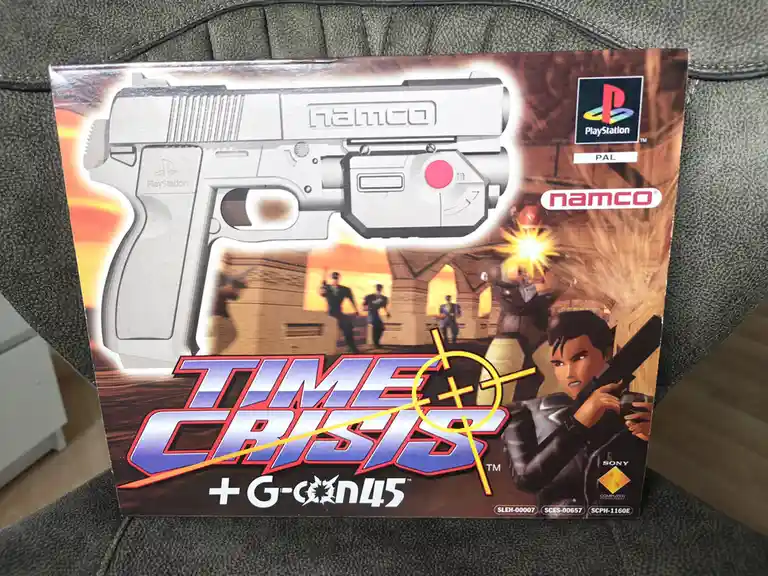A PlayStation game box for 'Time Crisis + G-Con45' featuring a large image of the Namco G-Con 45 light gun controller. The…