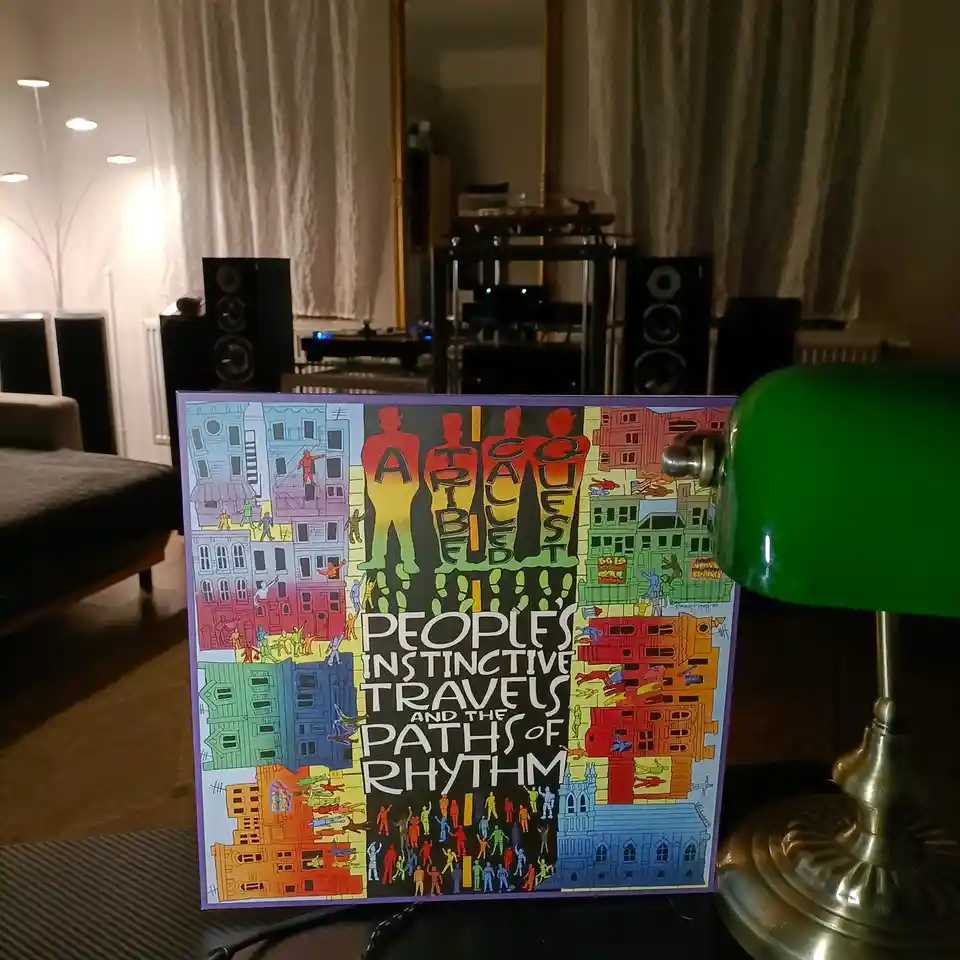 A vinyl record album cover for 'People's Instinctive Travels and the Paths of Rhythm' by A Tribe Called Quest is propped up…