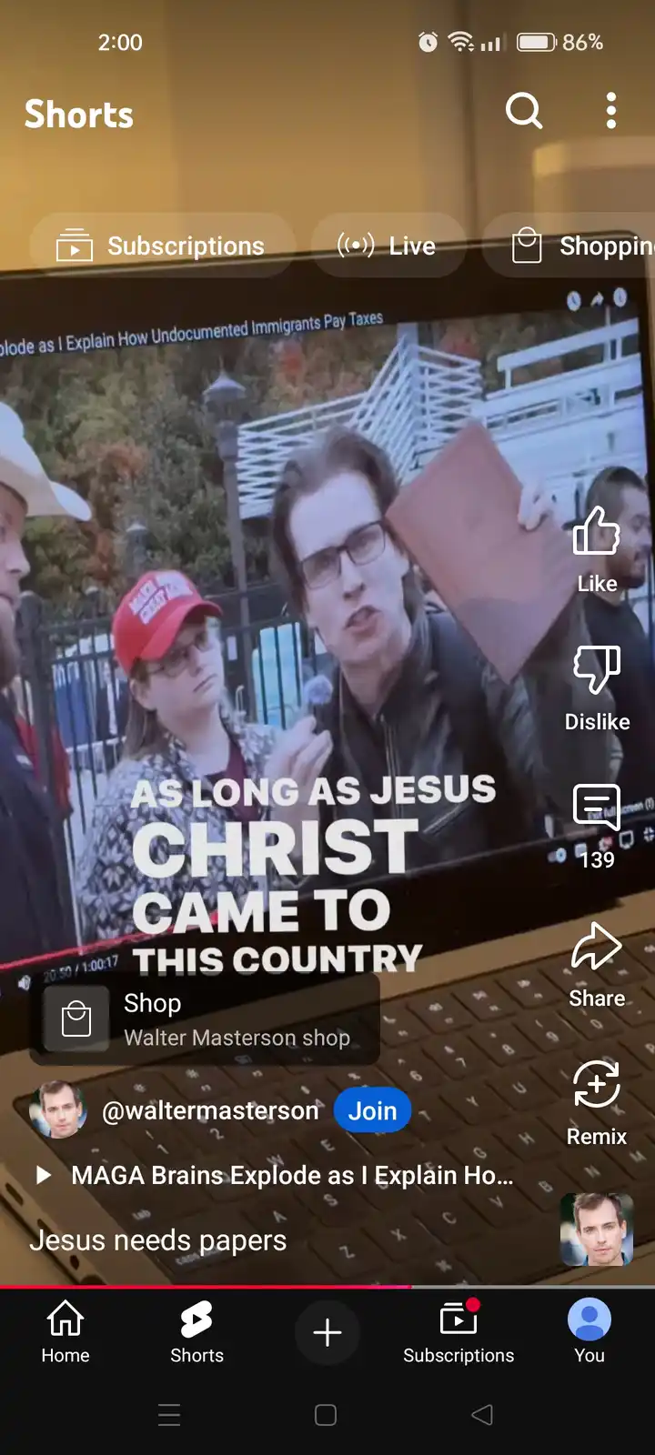 A screenshot of a YouTube Shorts interface shows a video playing on a laptop screen. The video features a man speaking while…