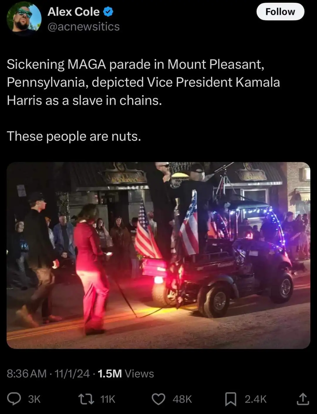 A nighttime street scene shows a parade float with American flags and people in costumes. A person in a red outfit is being…