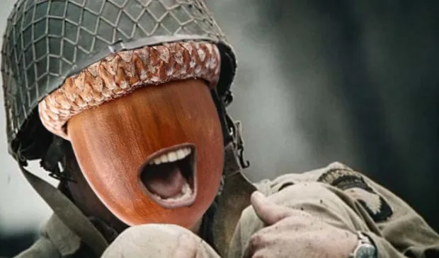A soldier in a military helmet and uniform has a wooden acorn-shaped head with a wide-open screaming mouth. The overlaid…