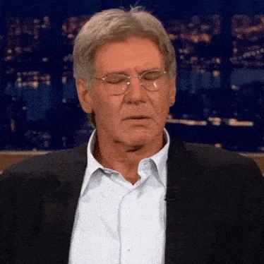 A six-panel image shows Harrison Ford in a suit and glasses, transitioning from a calm expression to an angry shout. The…